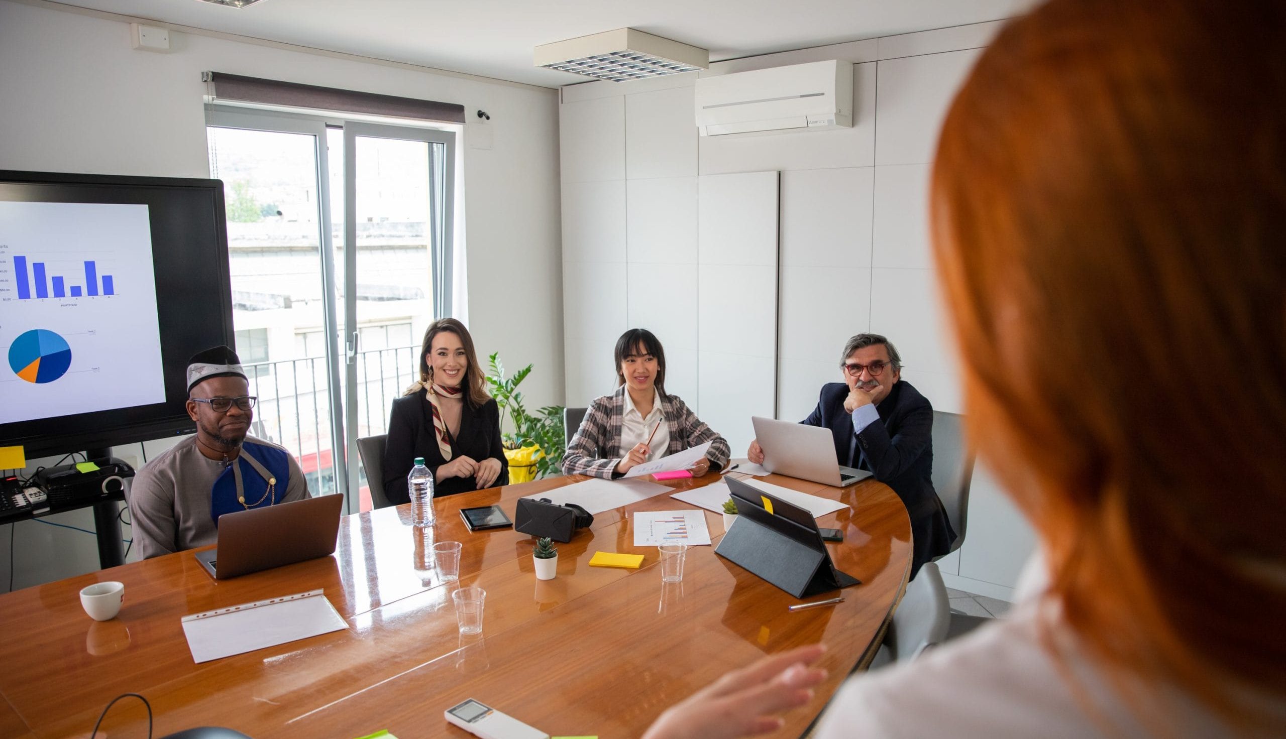 Business woman talking to her business partners at a meeting, multi ethnic group